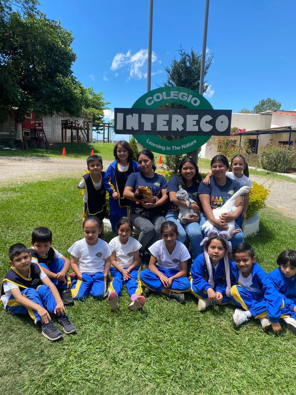 Estudiantes y maestros de Colegio Intereco reunidos frente al letrero del colegio